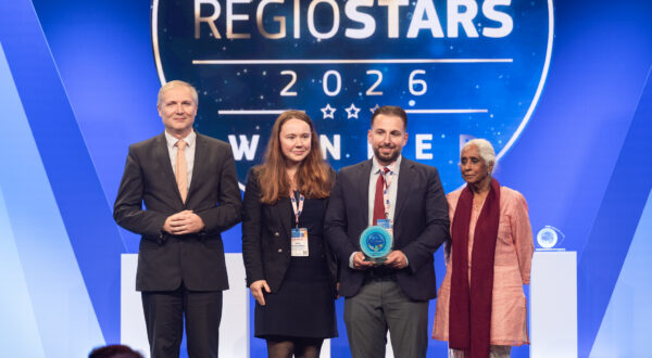 Vier Menschen vor einer Blauen Wand mit dem weißen Schriftzug "Regiostars 2026: WINNER"